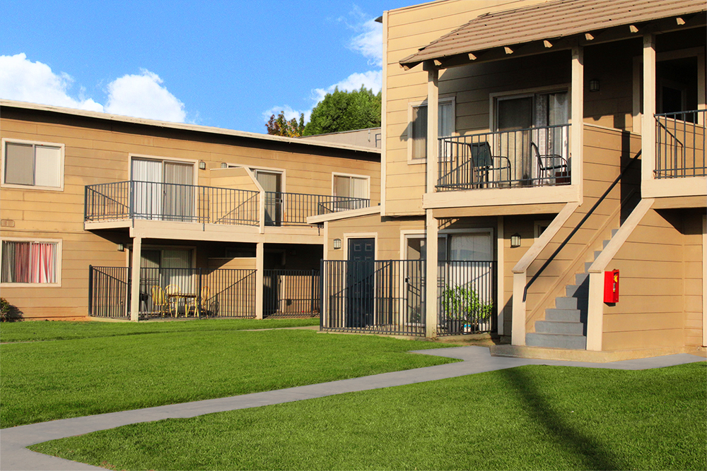 This image displays two-story building exterior photo of Village Square Apartments