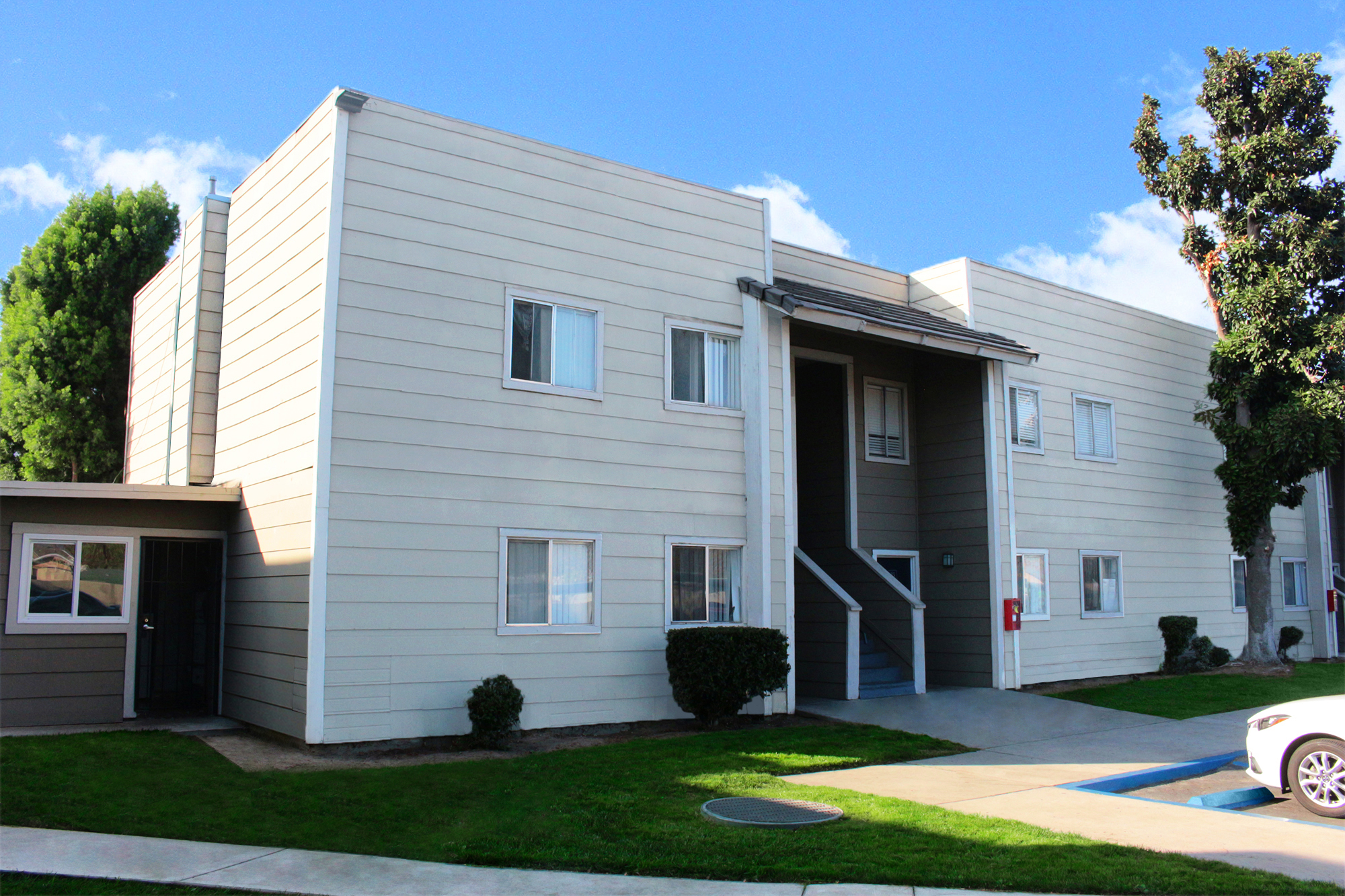 This banner image displays exterior photo of Village Square Apartments